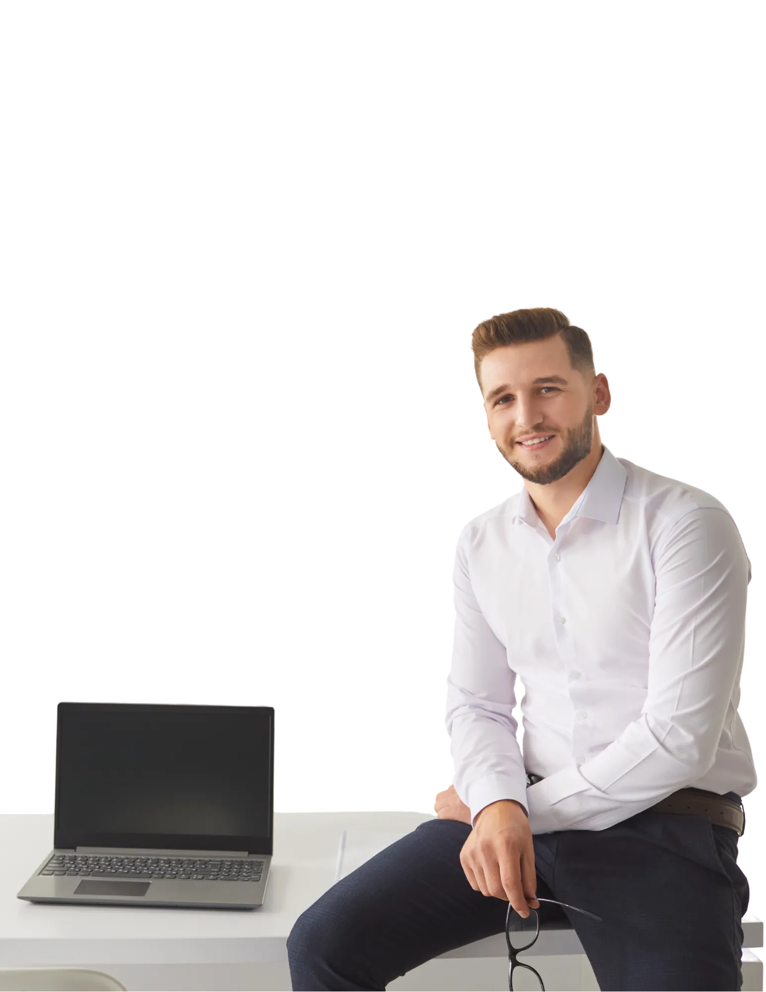 A consultant sitting on the edge of a desk beside an open laptop.