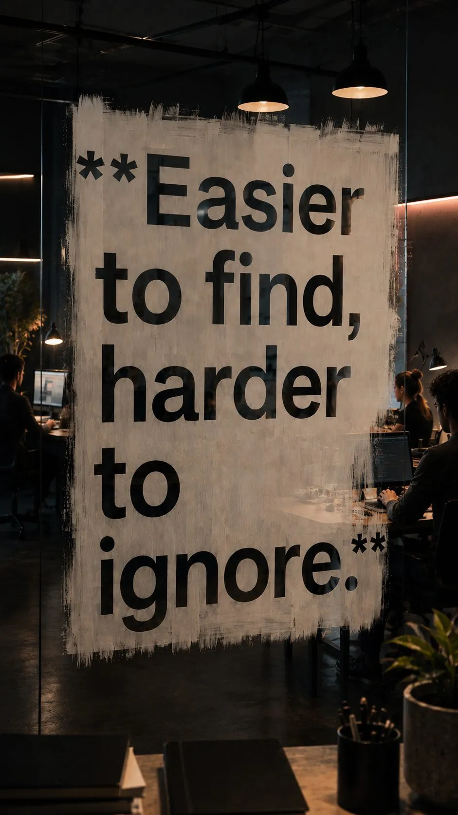 A wall mural in a darkened studio reading 'Easier to find, harder to ignore.' in oversized type — the brand promise painted at the scale of the room.